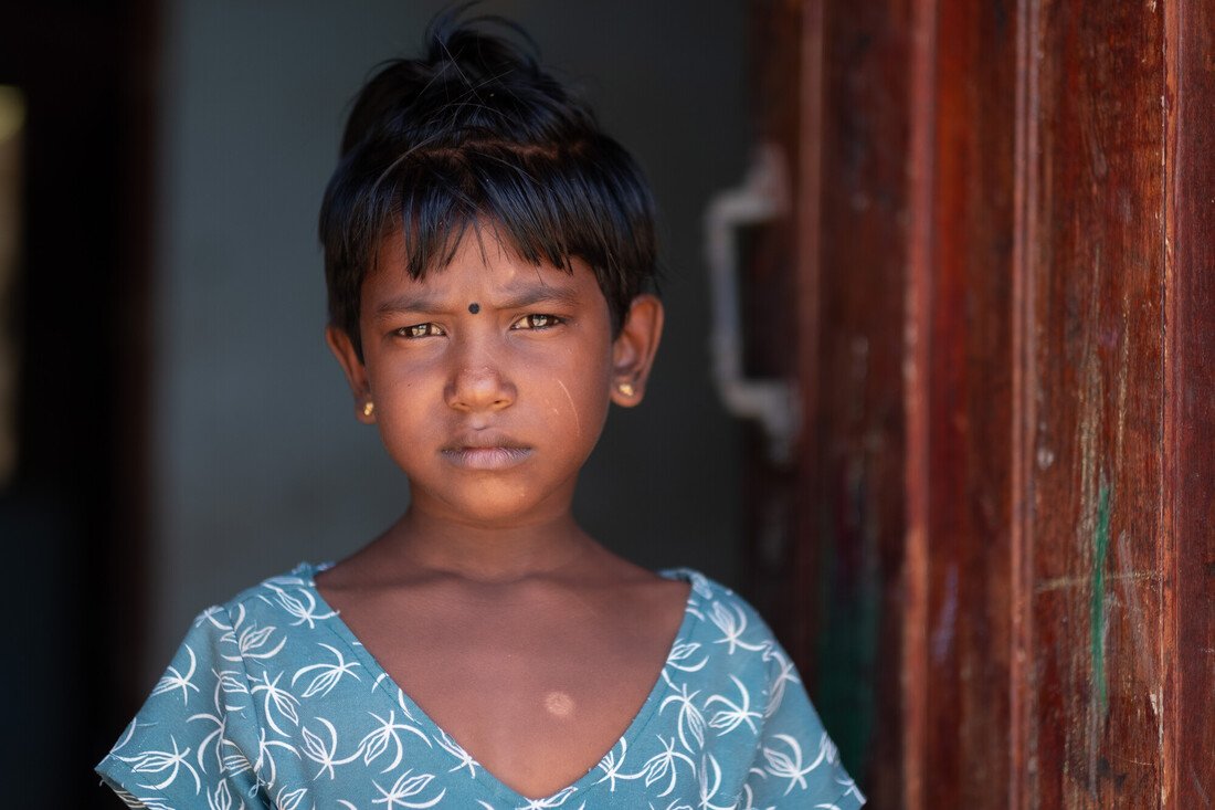 Chandani stands in a doorway looking at the camera