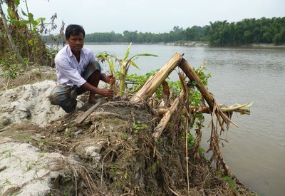 Rongit Roy has been treated for leprosy. He is pictured next to what was his rented farmland, now permanently flooded.jpg